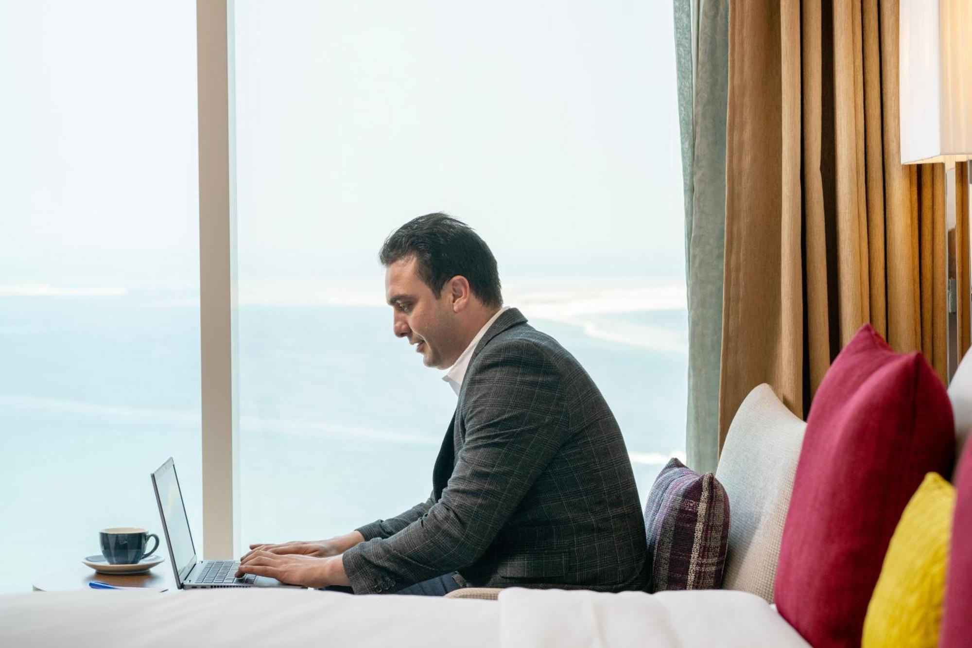 Delta Hotels By Marriott City Center Doha Bagian luar foto A businessman working on a laptop
