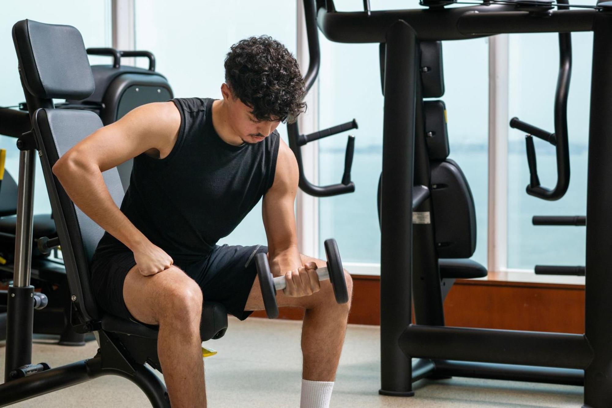 Delta Hotels By Marriott City Center Doha Bagian luar foto A man lifting weights