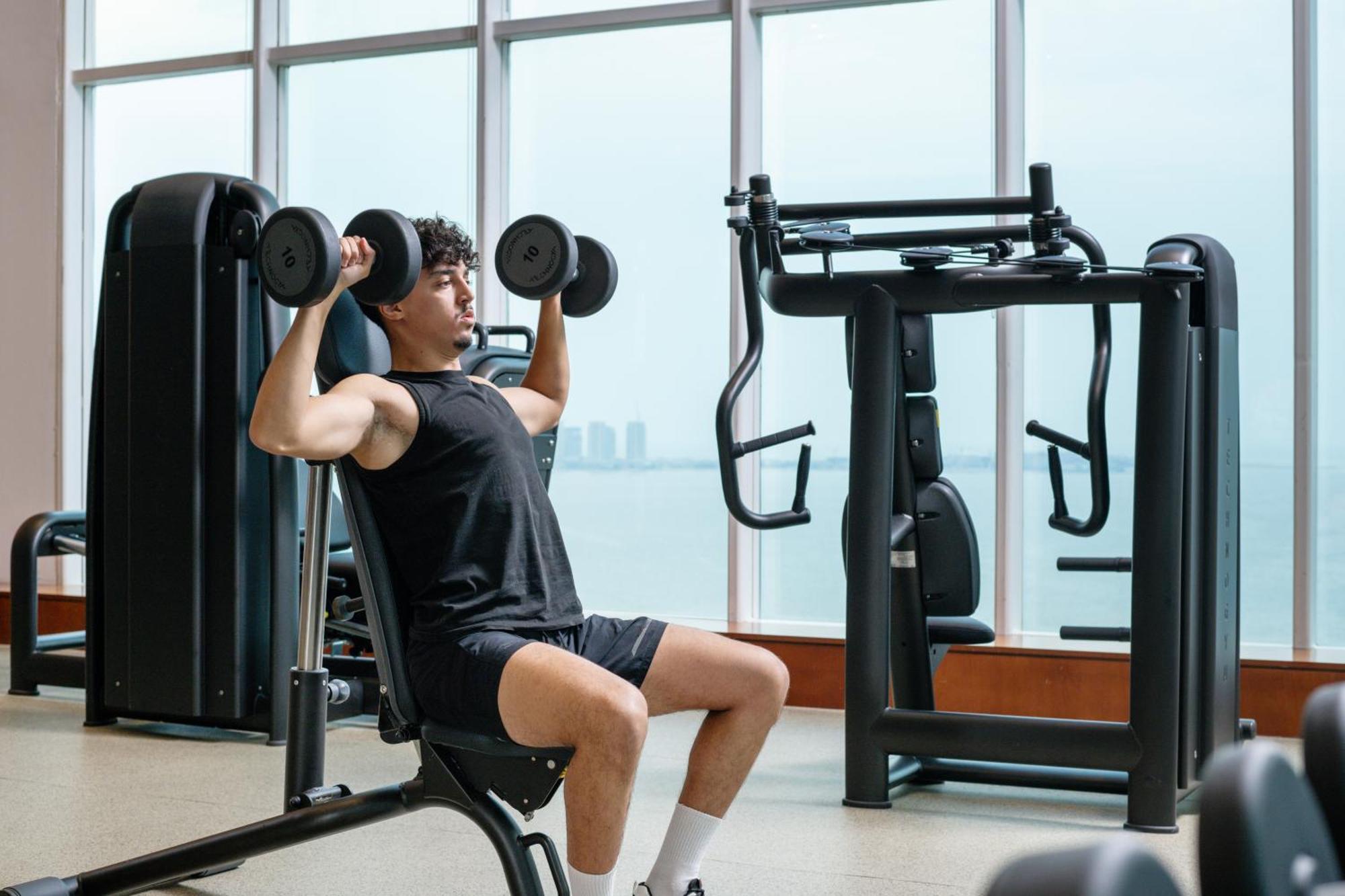 Delta Hotels By Marriott City Center Doha Bagian luar foto A man lifting weights